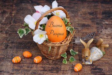 Cesto pasquale decorativo con uova di Pasqua, fiori e il saluto Buona Pasqua.