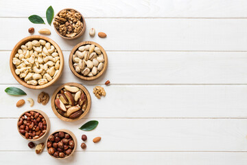 mixed nuts in wooden bowl. Mix of various nuts on colored background. pistachios, cashews, walnuts, hazelnuts, peanuts and brazil nuts