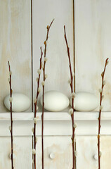 Easter eggs lying on shelf with Pussy willow twigs