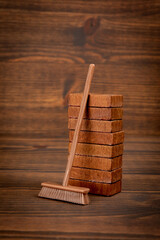 Miniature outdoor broom on wood texture background