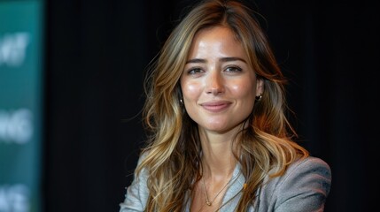 A woman with long hair smiles at the camera