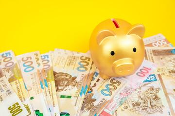 piggy bank and bank note on yellow background