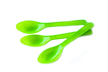 Green plastic disposable spoons isolated on white background. Concept, equipment for eating utensil, can be reuse or recycle.