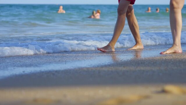 Couples' feet walking on sandy beach by the sea in 4k slow motion 120fps