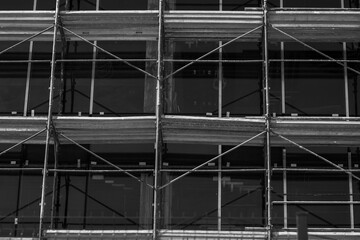 Modern Building Under Construction. Scaffolding, Glass Facade, Exterior Design. Black and white...