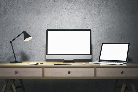 Modern minimalistic designer office interior with blank white computer and laptop monitors. Mock up, 3D Rendering.