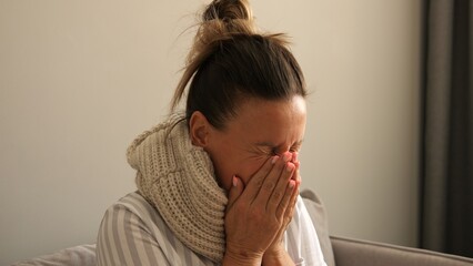 Woman at home battles flu evident in persistent coughs frequent sneezes and fever With flu symptoms...