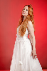 Copper-haired princess in a crown against a red wall - 752106660