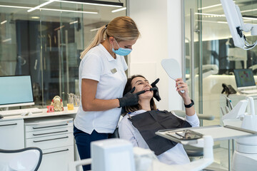 young female dentist is doing a dental examination of a girl patient in the dental office.
