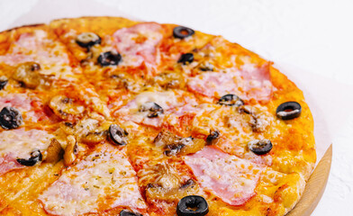 pizza with ham and mushrooms on a light background