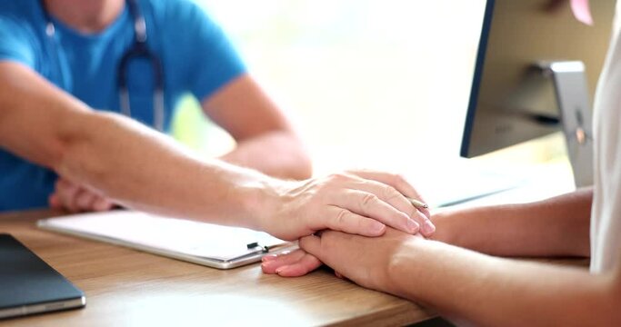 Doctor hand man calms female patient in clinic. Threat of miscarriage diagnosis treatment and medical care