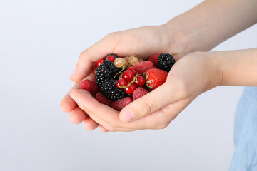 Ripe berries, in hands, close-up, on a light background.