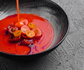 Tomato soup in a black bowl