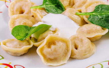 Boiled dumplings with basil on plate
