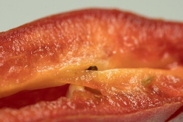 Fiery Elegance: Macro Shot of Red Chilli Seeds in Vivid Detail, An exquisite macro shot of a sliced red chilli pepper, revealing a vibrant display of seeds nestled within its juicy, deep red flesh.
