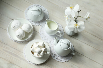 Spring breakfast with marshmallow, coffee and milk. Flatlay with food and flower in white color