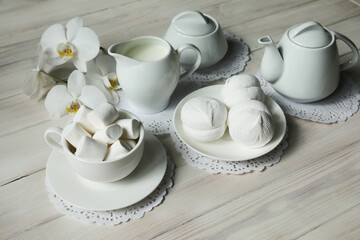 Spring breakfast with marshmallow, coffee and milk. Flatlay with food and flower in white color