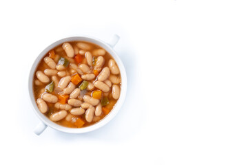 White beans soup with vegetables in white bowl isolated on white background. Top view. Copy space