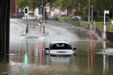 White car submerged in water after flooding in Scotland. © Wirestock