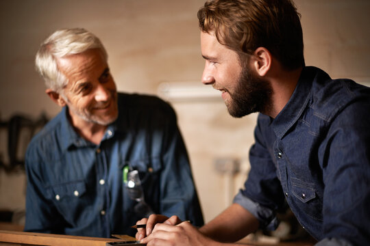 Man, job and smile with wood, workshop and family business or apprenticeship. Father, adult son and design with artisan, carpentry and together for startup and mentor or learning with happiness