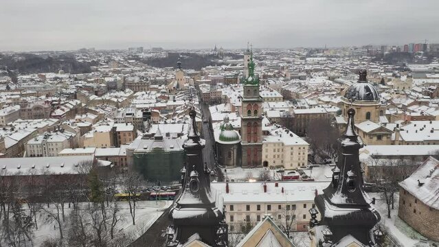 Aerial View of View of Winter Lviv. Snowy Roofs of Ancient City and Spires of Charming Old Churches. Drone Shot of Winter in the City Life. Touristic Place. Traveling. Historical Places Concept