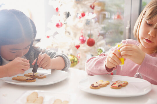 Two Young Girls Decorating Ginger bread man Biscuits
