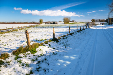 Paysage d'hiver. Route de campagne enneigée avec verglas à travers prairies et champs