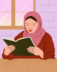 Muslim woman in hijab reading book at table
