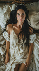 Fototapeta premium portrait of a woman in medieval, very long perfectly straight hair, looking up to camera, laying in bed