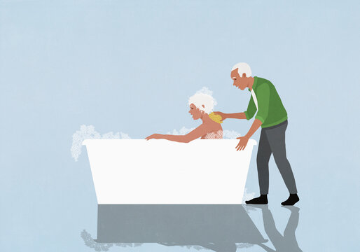 Affectionate senior husband scrubbing wife's back in bubble bath
