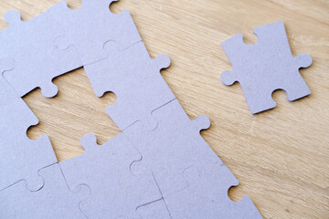 Fragment of folded jigsaw cardboard puzzle and pile uncombed puzzle elements against background, Education and Learning, memory improvement