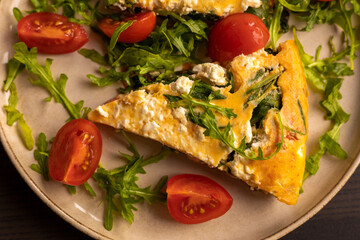 delicious spring frittata for a perfect brunch with arugula and cherry tomatoes close-up