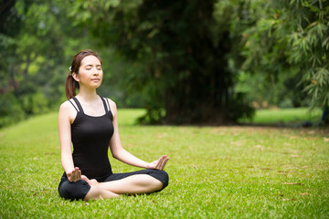 Naklejka na ściany i meble Chinese woman practicing yoga outdoors.