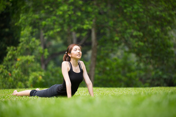 Naklejka na ściany i meble Chinese woman practicing yoga outdoors.