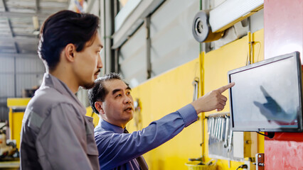 Qualified mechanic in garage using screen computer to follow checklist while doing maintenance on car, talking with client, updating information for customer, maintenance and repair car engine