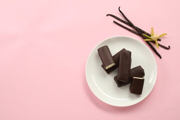 Glazed curd cheese bars, vanilla pods and flower on pink background, top view. Space for text