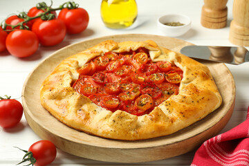 Tasty tomato galette (Caprese galette) on white wooden table, closeup