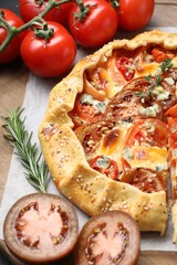 Tasty galette with tomato and cheese (Caprese galette) on wooden board, closeup