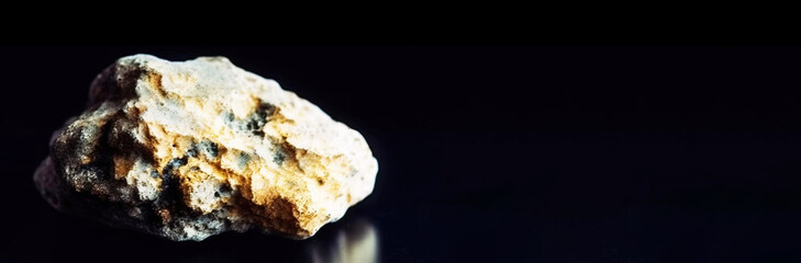 Bilinite is a rare precious natural stone on a black background. AI generated. Header banner mockup with space.