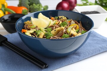 Stir-fry. Delicious cooked noodles with chicken and vegetables in bowl served on white table, closeup