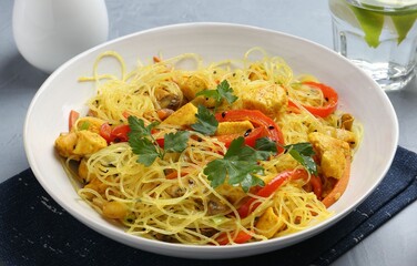 Stir-fry. Delicious cooked noodles with chicken and vegetables in bowl on table, closeup