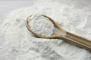 Obraz na płótnie Canvas Pile of baking powder and spoon on table, closeup