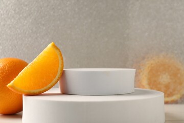 Presentation for product. Podium and tasty fresh oranges on table, closeup. Space for text