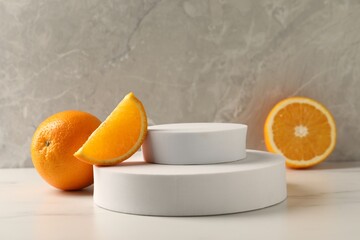 Presentation for product. Podium and tasty fresh oranges on white table, space for text