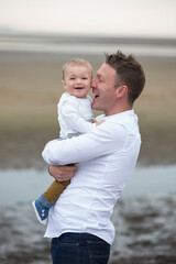 Dad and baby son at the beach.