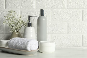 Different bath accessories, personal care products and gypsophila flowers in vase on white table...