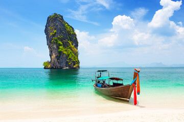 Thai traditional wooden longtail boat and beautiful sand beach at Koh Poda island in Krabi province, Thailand.