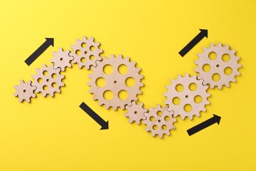 Business process organization and optimization. Scheme with wooden figures and arrows on yellow background, top view