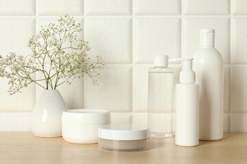 Bath accessories. Different personal care products and gypsophila flowers in vase on wooden table...