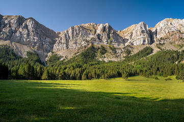 Fototapeta na wymiar Picturesque mountain landcaspe with blue sky and green valley (high cliff mountain range)